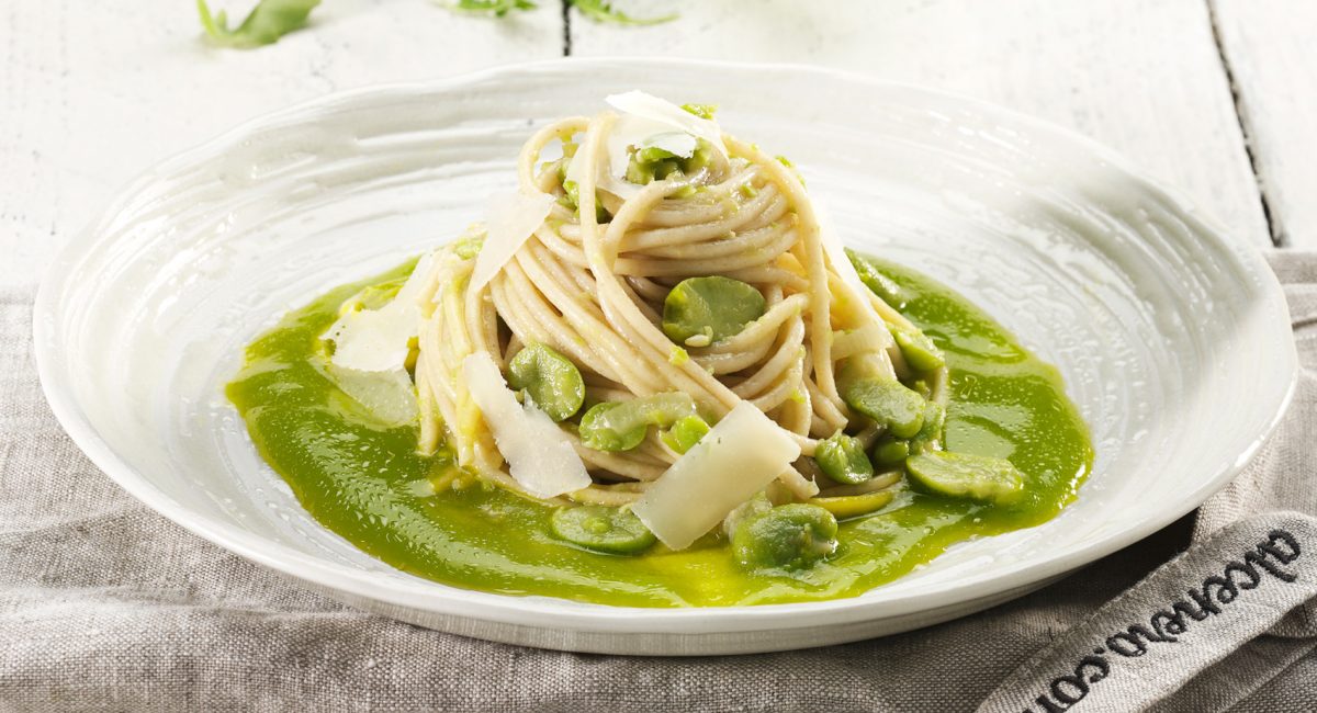 Espaguetis de espelta con pesto de habas, queso pecorino y crema de rúcula